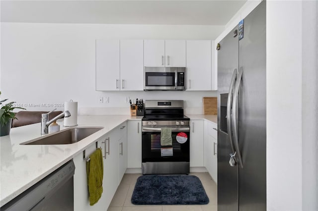 kitchen with appliances with stainless steel finishes, sink, and white cabinets