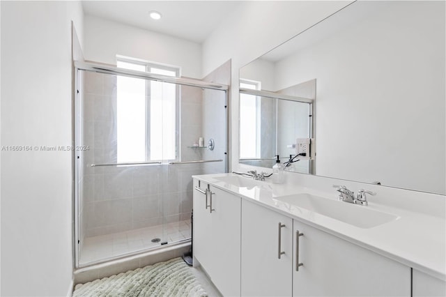 bathroom with a shower with shower door and vanity