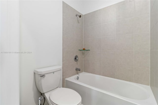 bathroom with tiled shower / bath combo and toilet