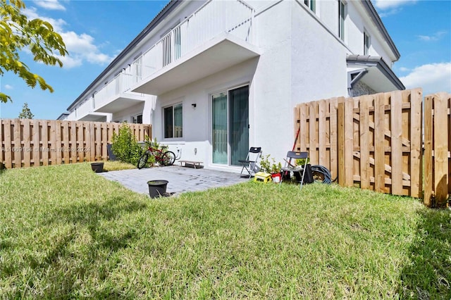 back of house featuring a lawn and a patio