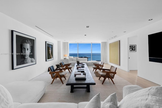 living room featuring light wood-type flooring and floor to ceiling windows