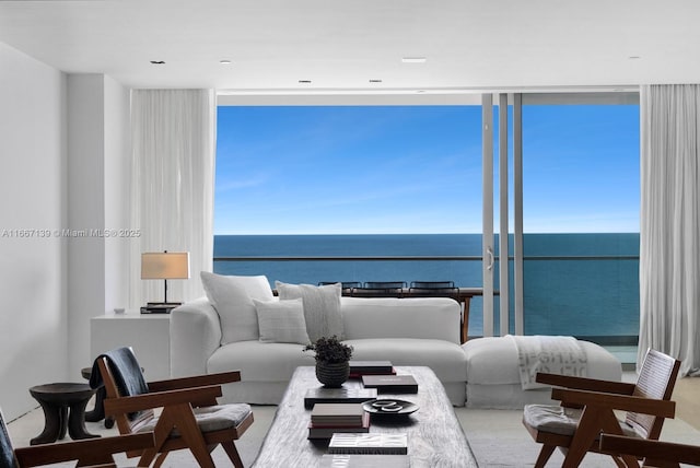 living room featuring floor to ceiling windows, plenty of natural light, and a water view