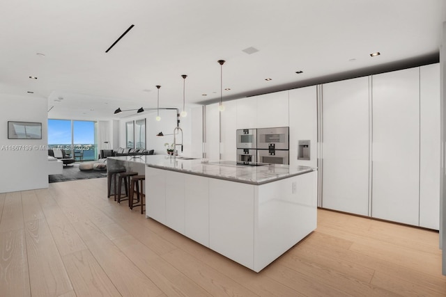 kitchen featuring a spacious island, pendant lighting, and white cabinets