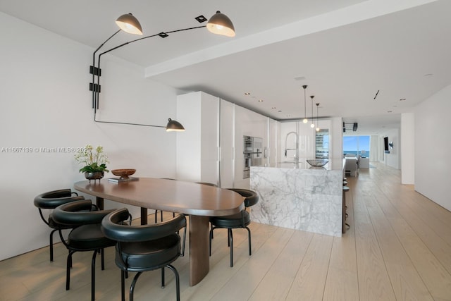 dining area with sink and light hardwood / wood-style flooring