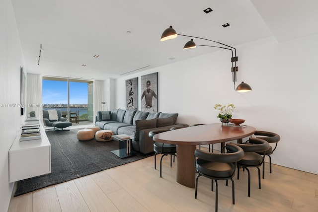 dining area with light hardwood / wood-style floors and a wall of windows