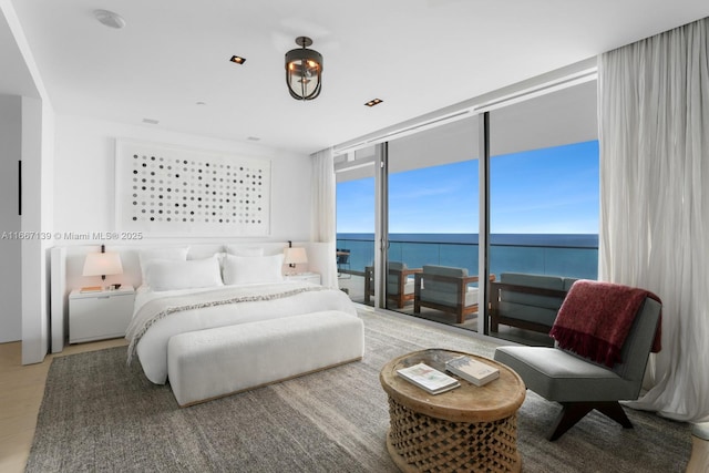 bedroom featuring a wall of windows and a water view