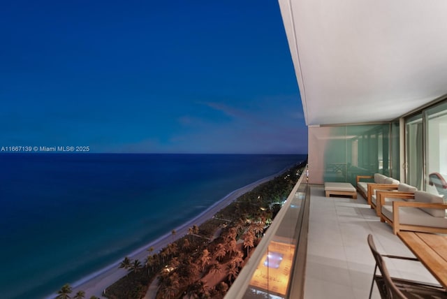 balcony featuring a water view and a view of the beach