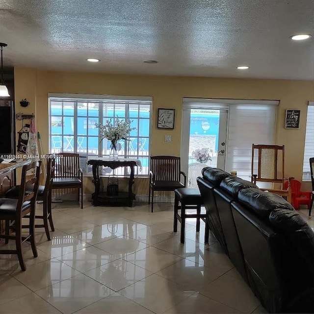 living room with a textured ceiling and light tile patterned flooring