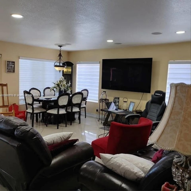 living room featuring light tile patterned flooring, a textured ceiling, and a wealth of natural light