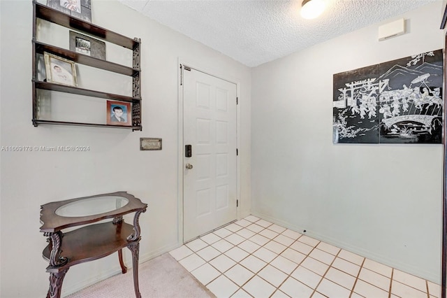 tiled entrance foyer featuring a textured ceiling