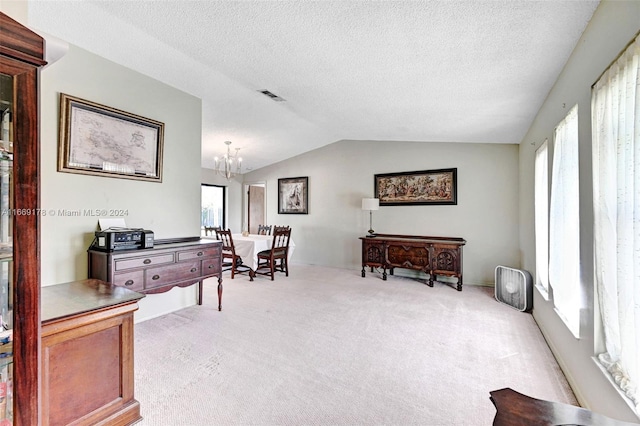 office featuring an inviting chandelier, a wealth of natural light, vaulted ceiling, and light carpet