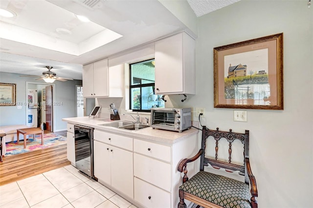 kitchen featuring light hardwood / wood-style flooring, white cabinetry, ceiling fan, and sink