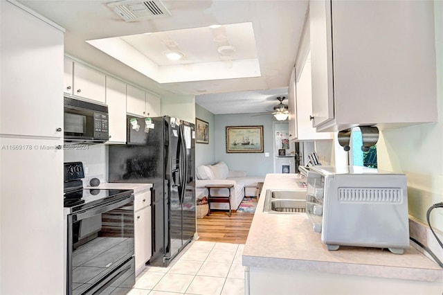 kitchen featuring light hardwood / wood-style floors, white cabinets, black appliances, ceiling fan, and sink