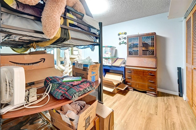 bedroom featuring a textured ceiling, light hardwood / wood-style floors, and a closet