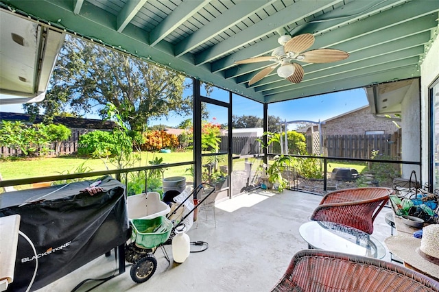 sunroom / solarium featuring beam ceiling and ceiling fan