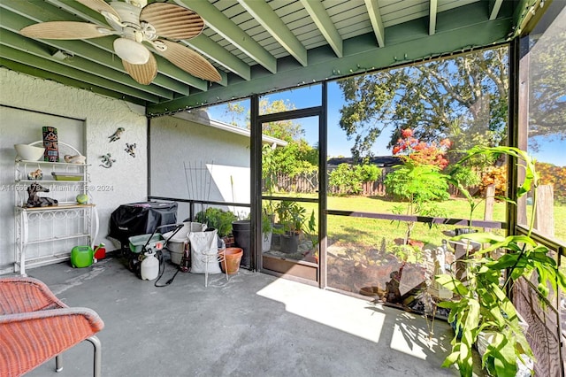 sunroom featuring beam ceiling and ceiling fan