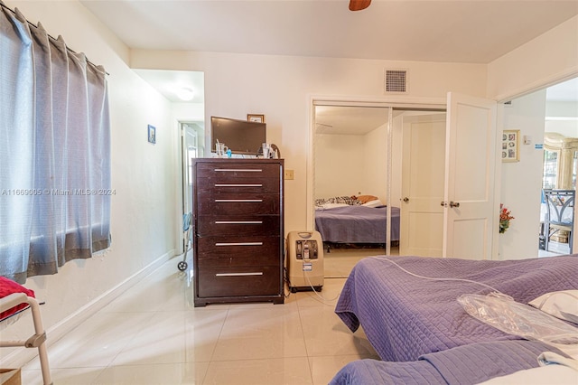 bedroom featuring ceiling fan, a closet, and light tile patterned floors