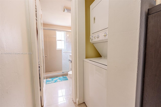 washroom with light tile patterned floors and stacked washing maching and dryer