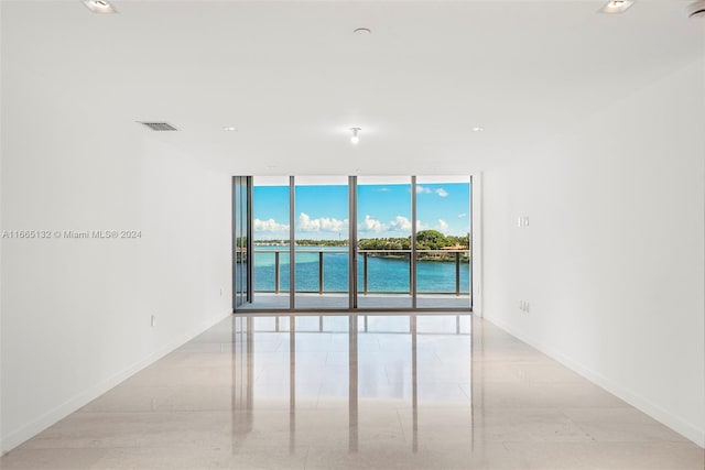 empty room featuring floor to ceiling windows and a water view