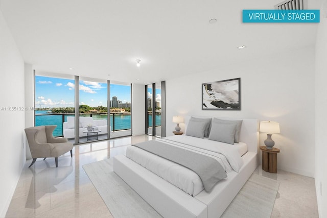 bedroom featuring a water view, a wall of windows, and access to outside