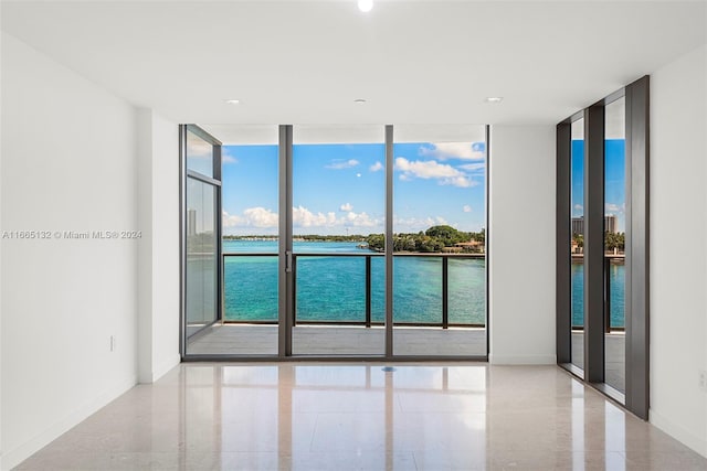 empty room with floor to ceiling windows and a water view