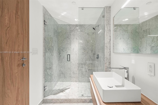 bathroom with hardwood / wood-style flooring, an enclosed shower, and sink