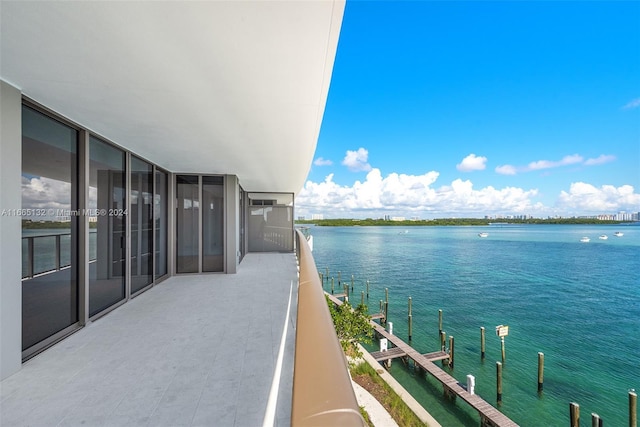 balcony with a water view and a dock