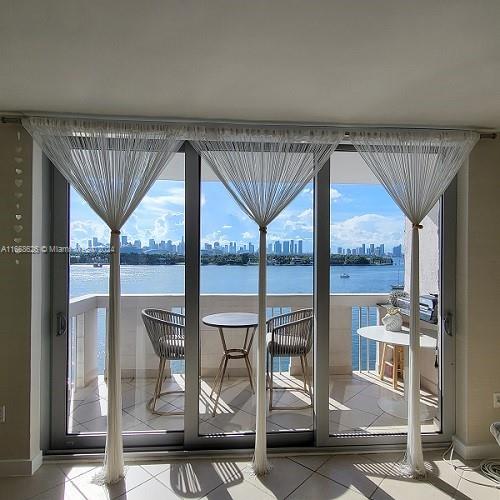 entryway featuring a water view and tile patterned floors