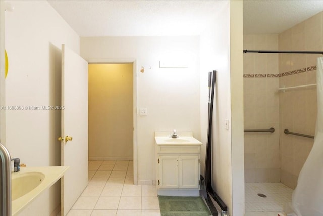 bathroom with tile patterned flooring, vanity, a shower stall, and a textured ceiling