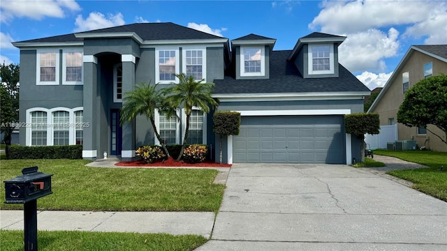 view of front facade featuring central air condition unit, a front yard, and a garage