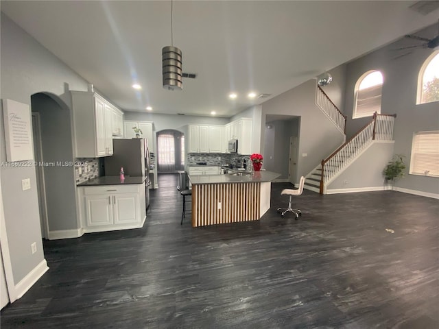 kitchen featuring white cabinets, a kitchen breakfast bar, decorative backsplash, and kitchen peninsula