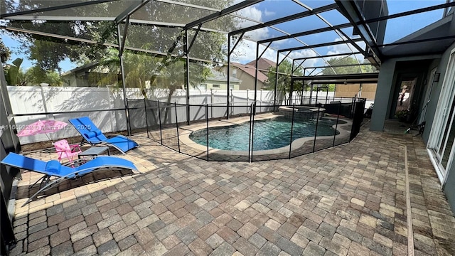 view of pool featuring an in ground hot tub, a patio, and glass enclosure