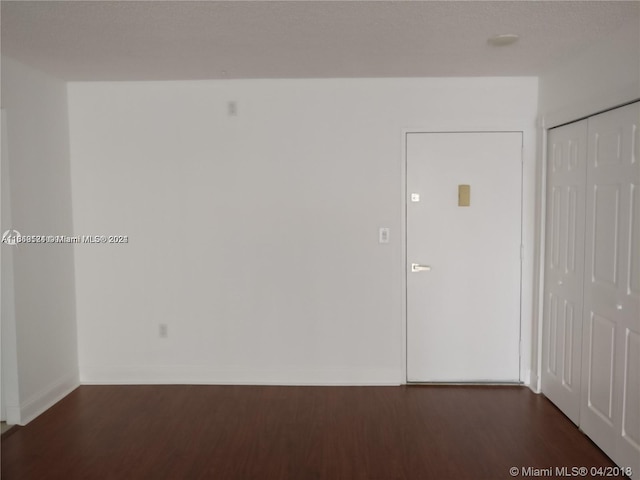 empty room featuring dark wood-type flooring