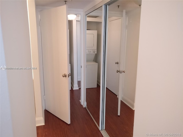 hall with dark hardwood / wood-style floors and stacked washing maching and dryer