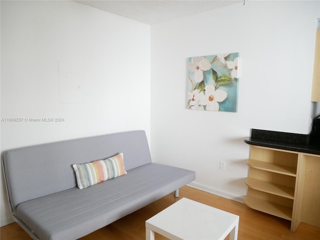 living area with wood-type flooring and a textured ceiling