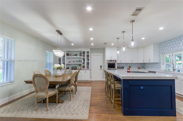 kitchen with white cabinetry, stainless steel oven, a center island, and pendant lighting