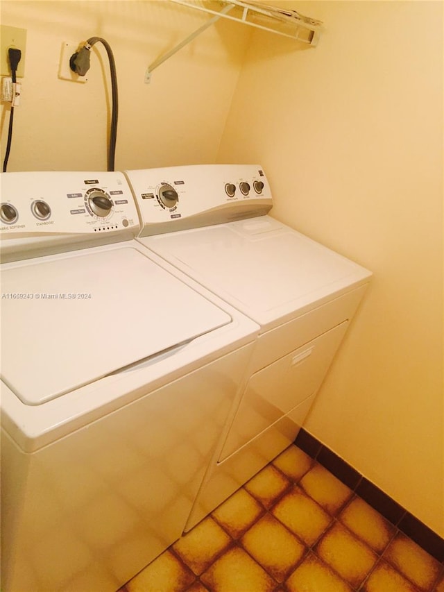 laundry area with separate washer and dryer and tile patterned flooring