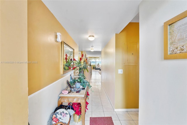 hallway featuring electric panel and light tile patterned floors