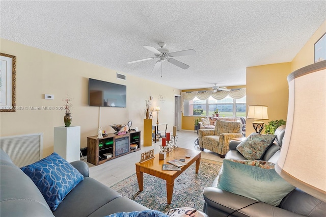 living room with ceiling fan and a textured ceiling