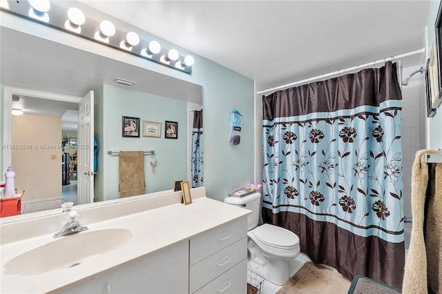 bathroom featuring visible vents, toilet, vanity, a shower with curtain, and tile patterned floors