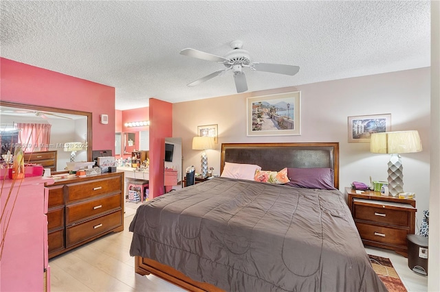 bedroom with ceiling fan, a textured ceiling, and light wood-type flooring