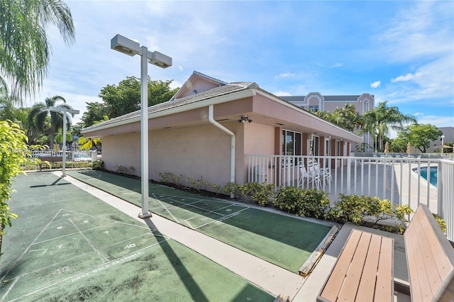 surrounding community with fence and shuffleboard