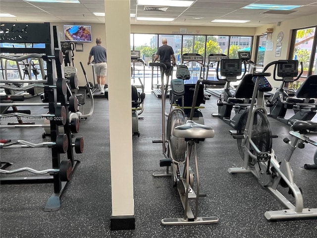 gym with a healthy amount of sunlight, visible vents, and a drop ceiling