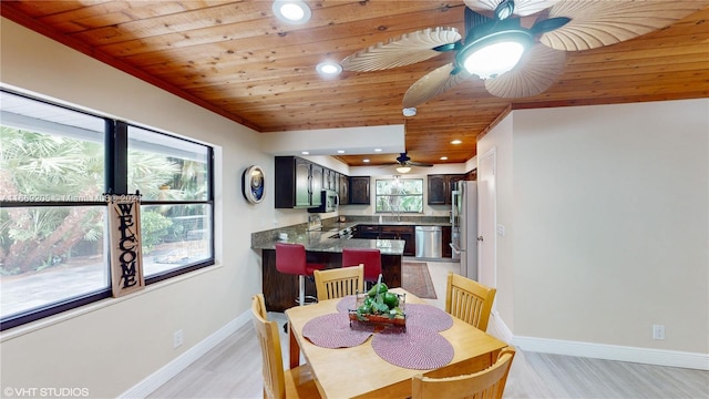 dining room with sink, wood ceiling, and light hardwood / wood-style floors