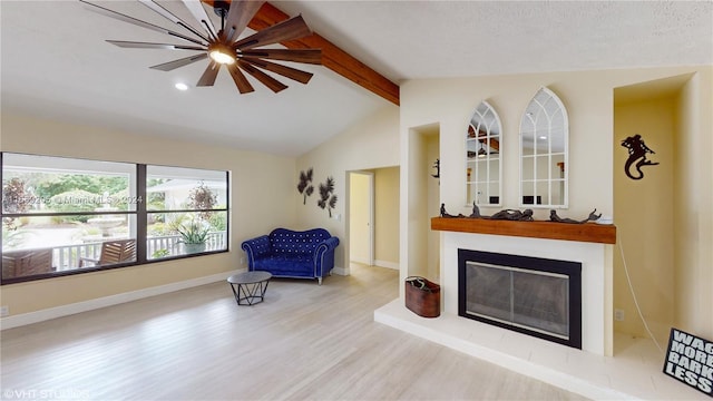 living area featuring vaulted ceiling with beams, hardwood / wood-style floors, and a textured ceiling