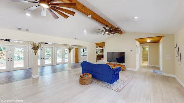 living room featuring vaulted ceiling with beams, light wood-type flooring, and french doors