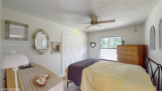 bedroom with wood-type flooring, a textured ceiling, a closet, and ceiling fan