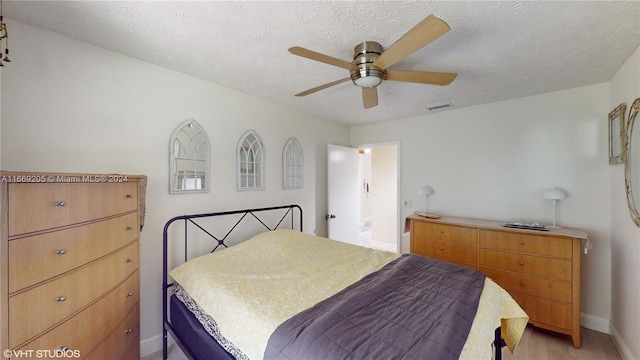 bedroom featuring ceiling fan and a textured ceiling