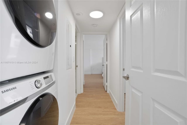 laundry area with light wood-type flooring and stacked washer / drying machine