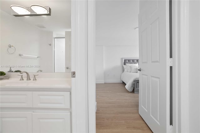 bathroom featuring hardwood / wood-style flooring, a shower with door, and vanity